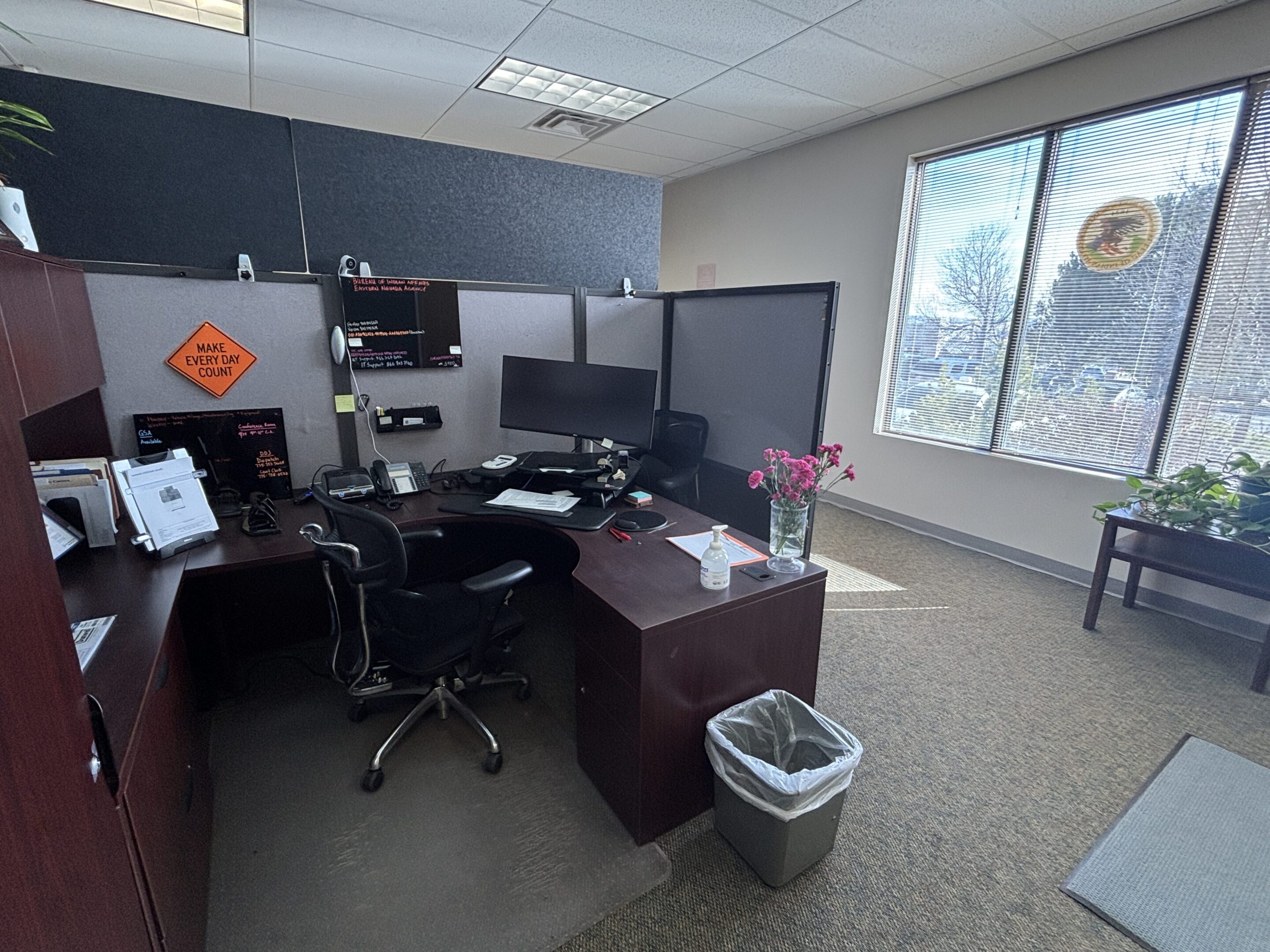 A large office with two desks and a chair.